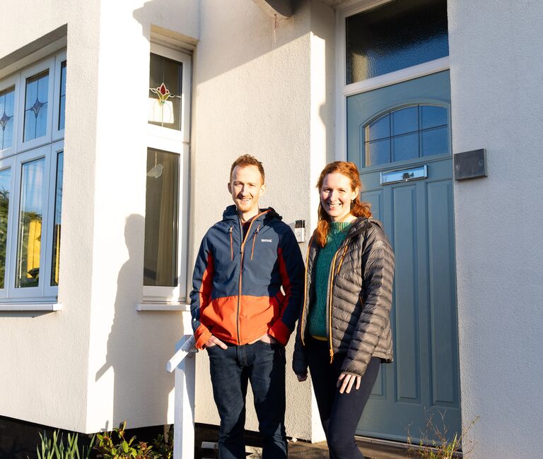 Couple standing by their front door
