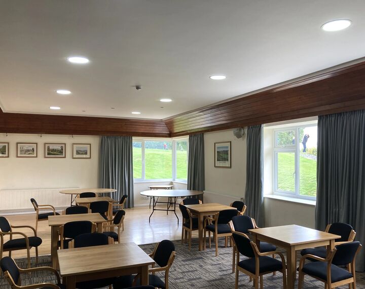 Inside club house with tables and chairs and new ceiling lighting 