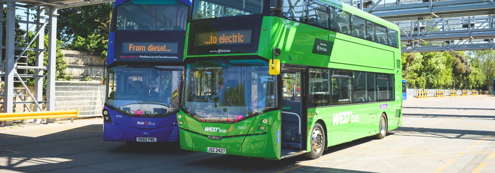 a blue double decker bus next to a green double decker bus