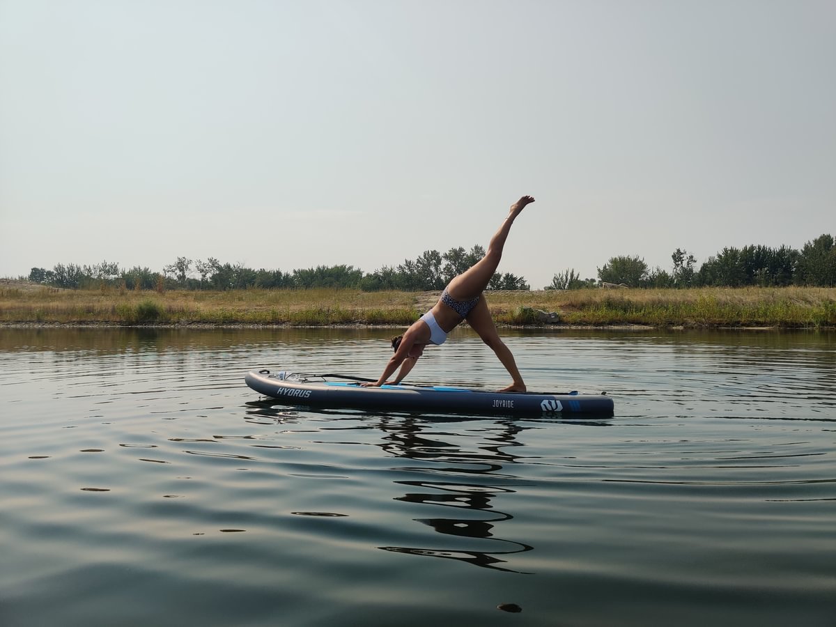 woman on paddle board doing yoga