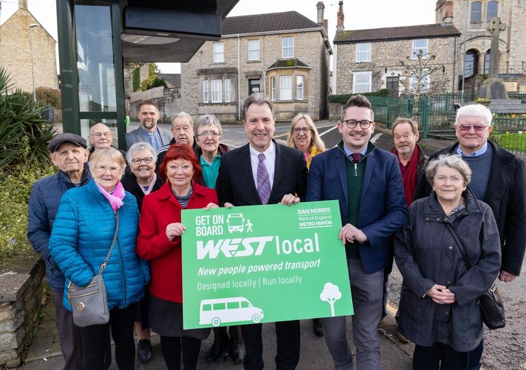 Mayor Dan Norris, Paulton Parish Councillors and local residents by the bus stop holding a sign saying WESTlocal in Paulton High Street, Paulton