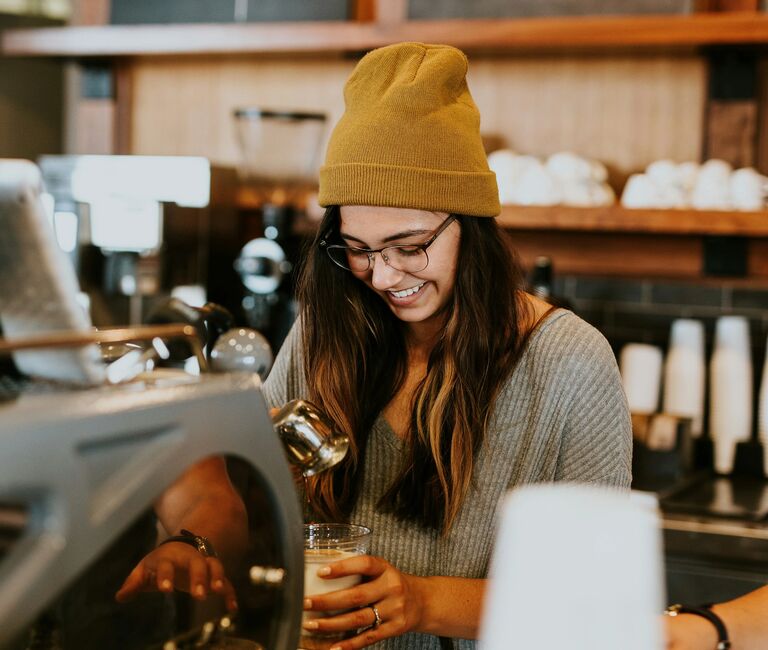Barista making coffee in a hat