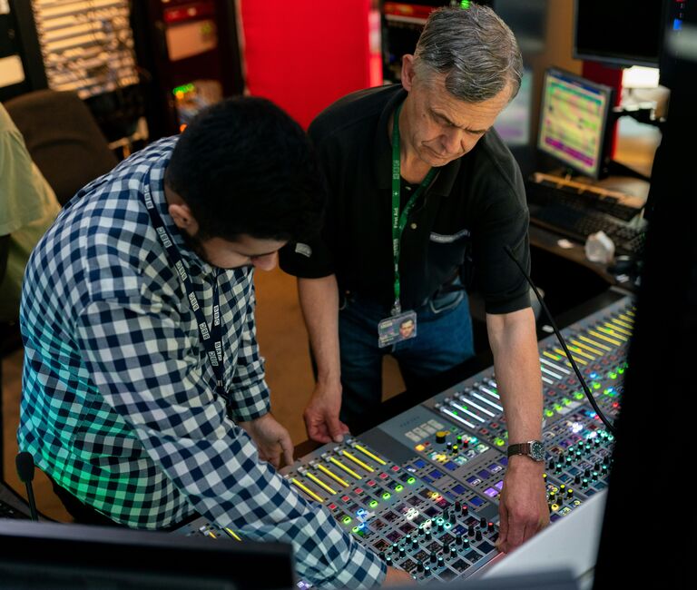 Two people looking at a sound-desk