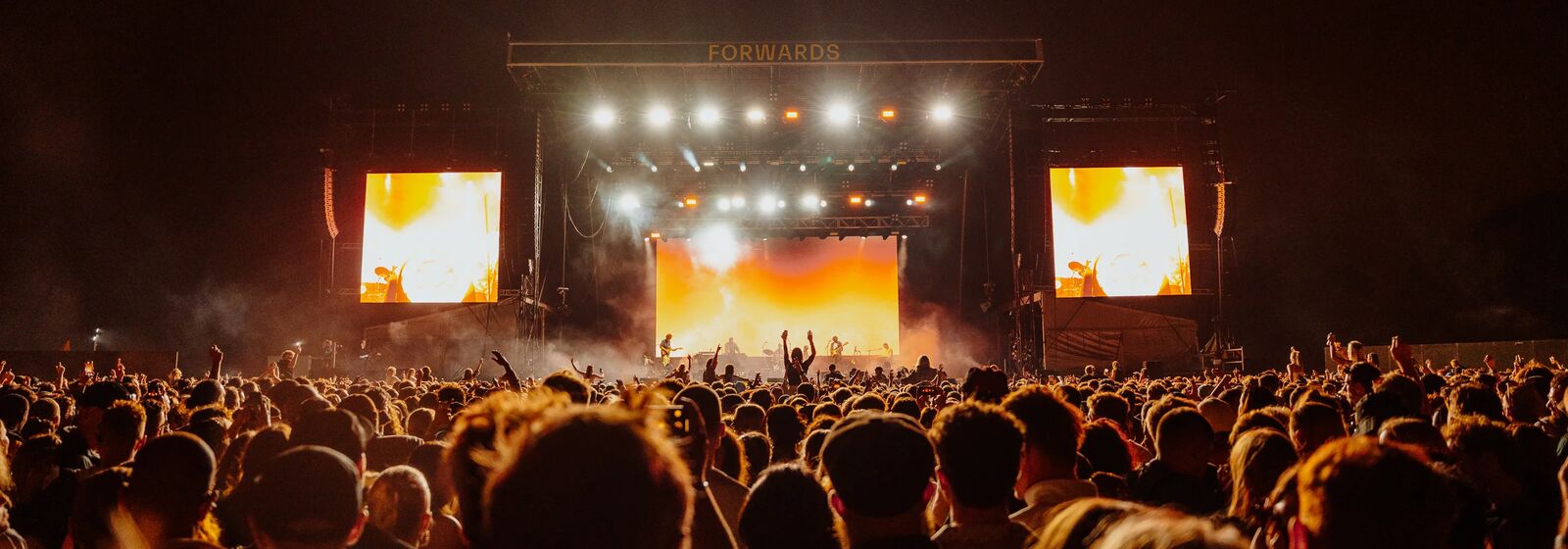 crowds in front of a stage at a music festival