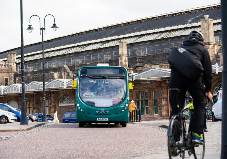 Taxis, a bus and a cyclist in front of Bristol Temple Meads station.