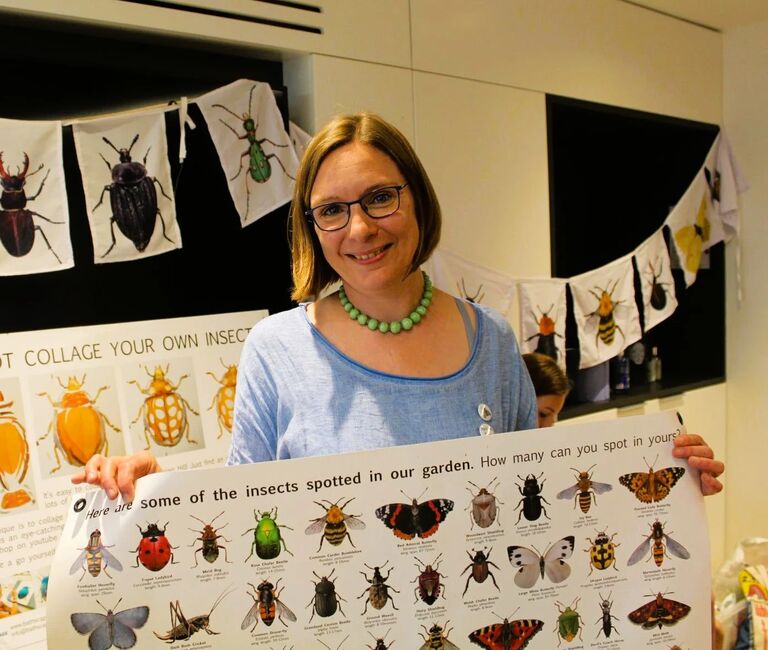 Person holding a poster with bugs on