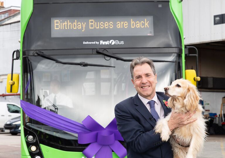 Mayor Dan Norris with his dod Angel standing behind a bus