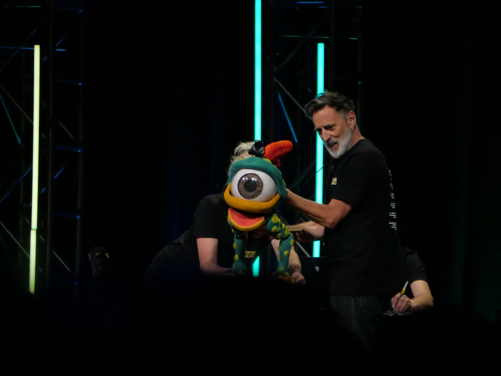 Three people operating a puppet