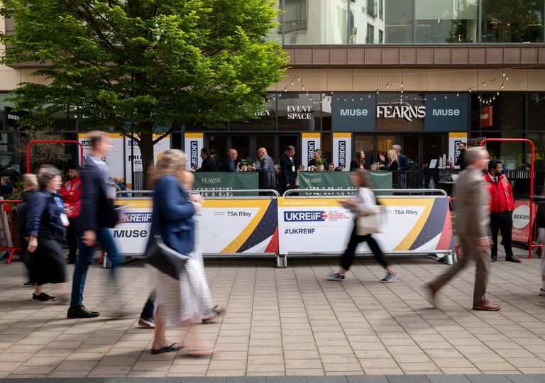 people walking past ukreiif barriers