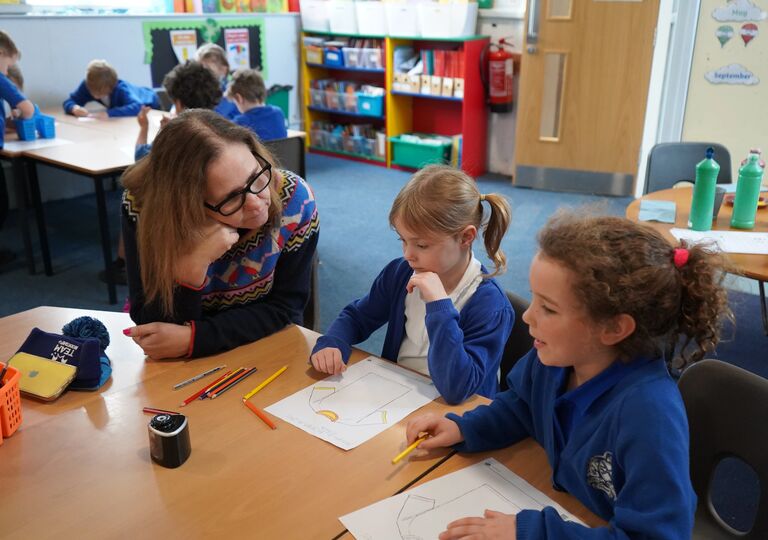 Mayor Helen Godwin listens to two young children in a classroom