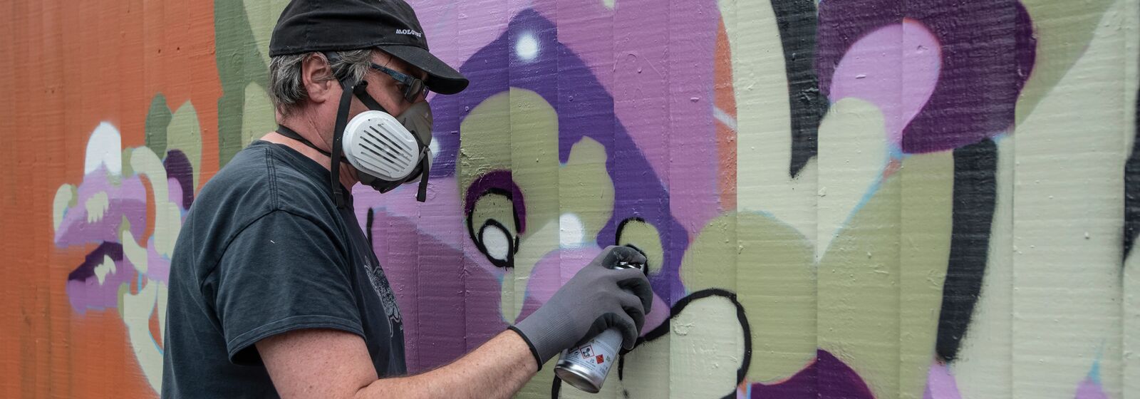 Andy Council, a local artist, is pictured painting a colourful mural.