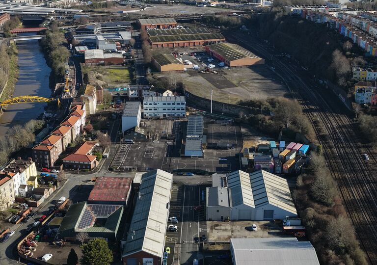 aerial view of industrial buildings with river and yellow bridge