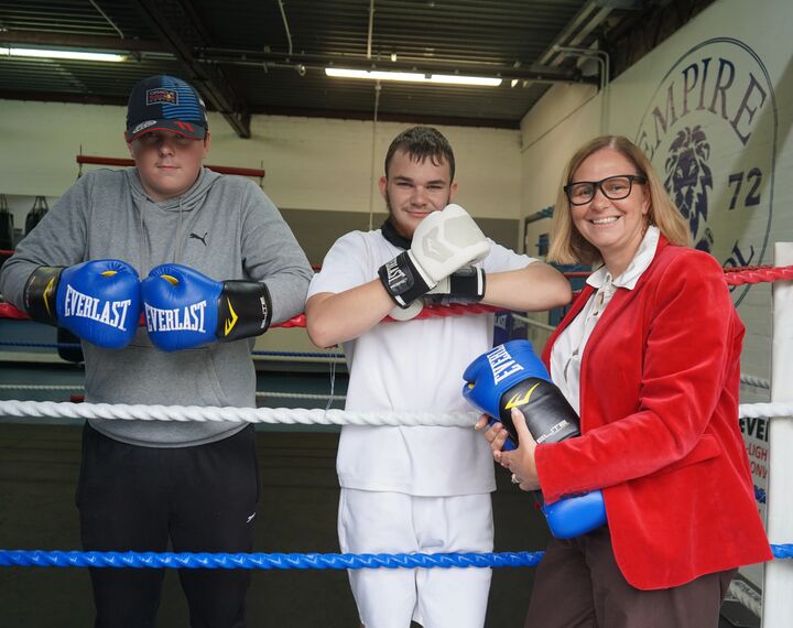 the Mayor with two young people standing in a boxing ring