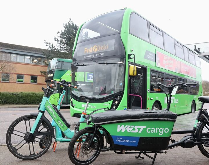 Buses, scooters, bikes, and cargo bikes are pictured at a WESTbusStop+