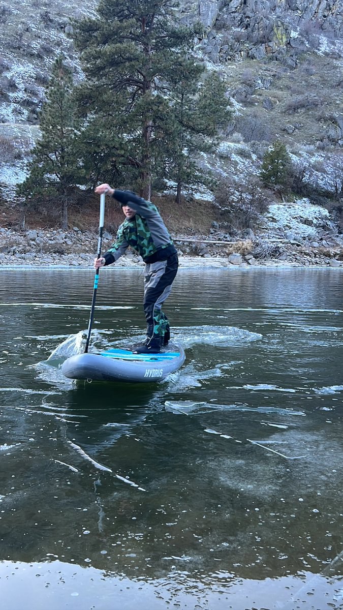 man in drysuit paddling in icy water
