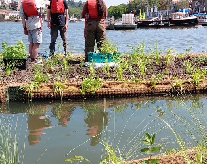 three people wearing life jackets, installing a floating ecosystem
