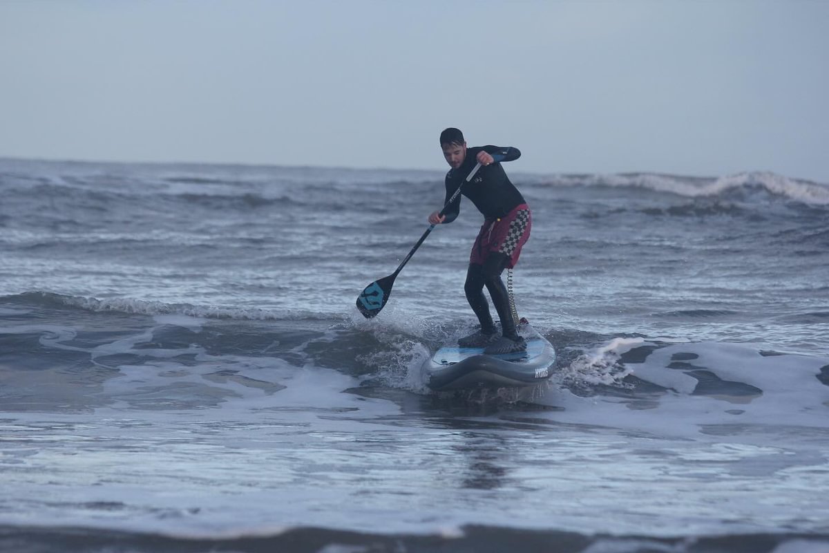 man paddle board surfing in the ocean with Hydrus Board tech gear