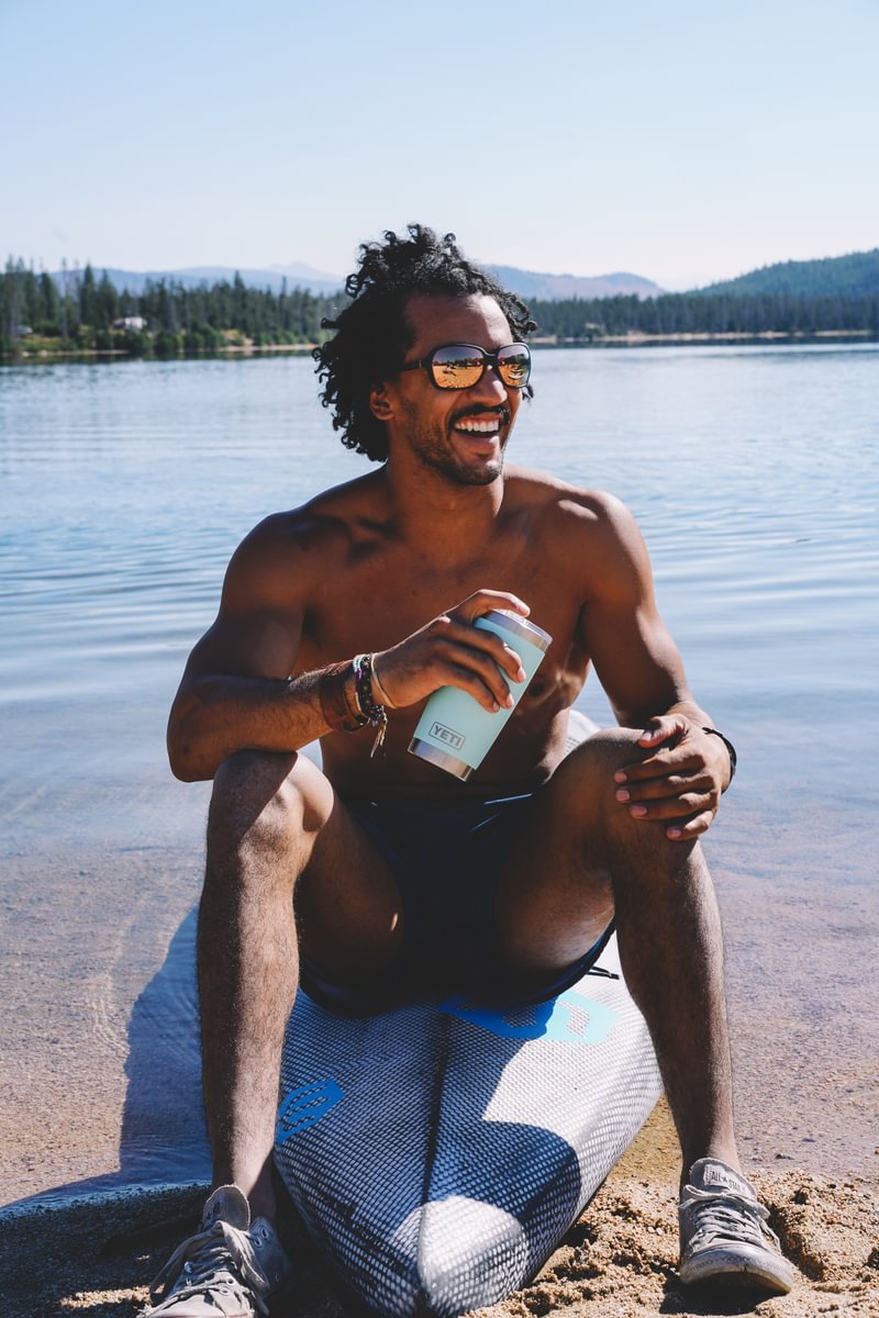 man laughing sitting on a paddle board