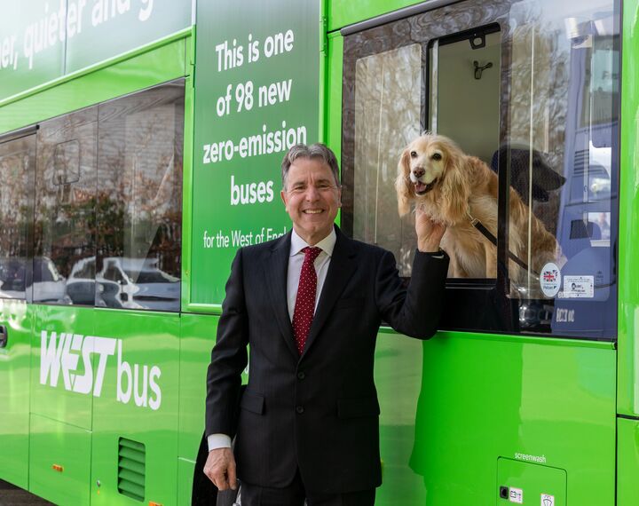 Mayor Dan Norris is pictured with a green WESTbus with his dog, Angel.
