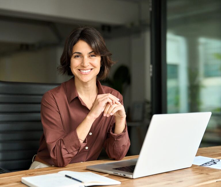 Office worker at laptop smiling