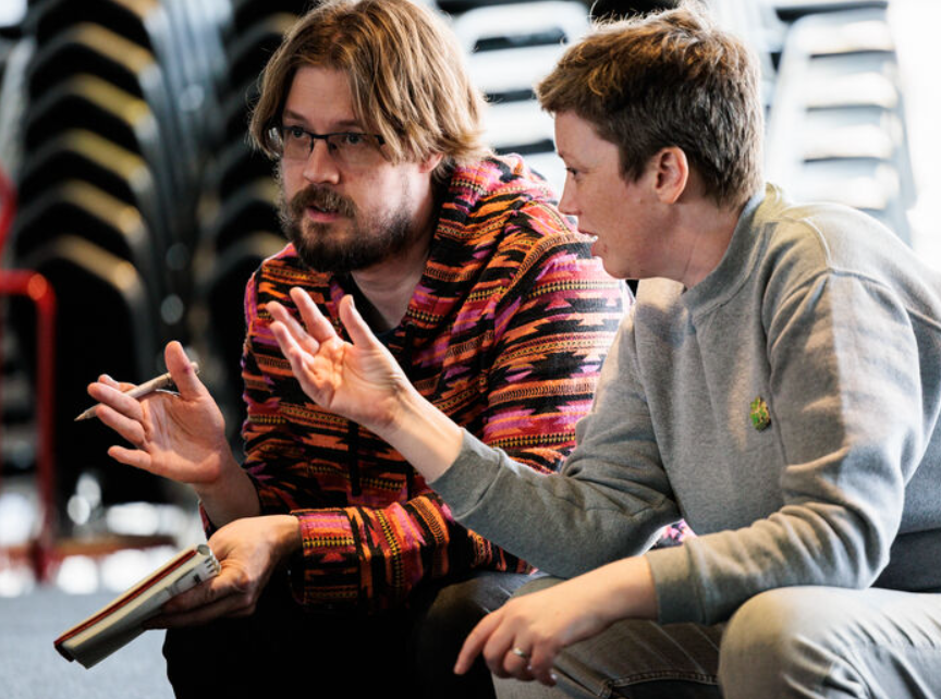 Man and woman talking, gesturing with their hands