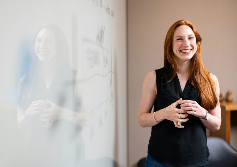 Smiling person at a whiteboard