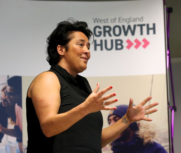 Person speaking at an event - words in background read 