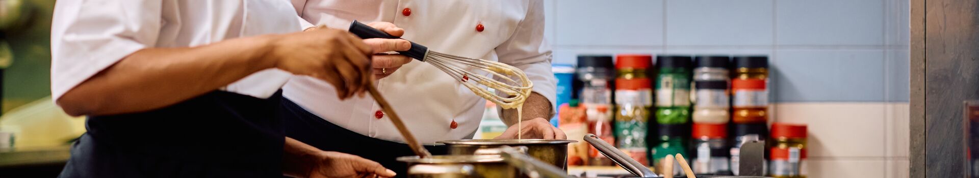 two chefs cooking food in a kitchen
