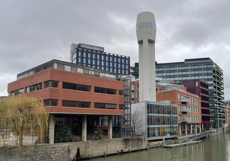 exterior of brutalist redbrick building with a tall grey tower in the centre