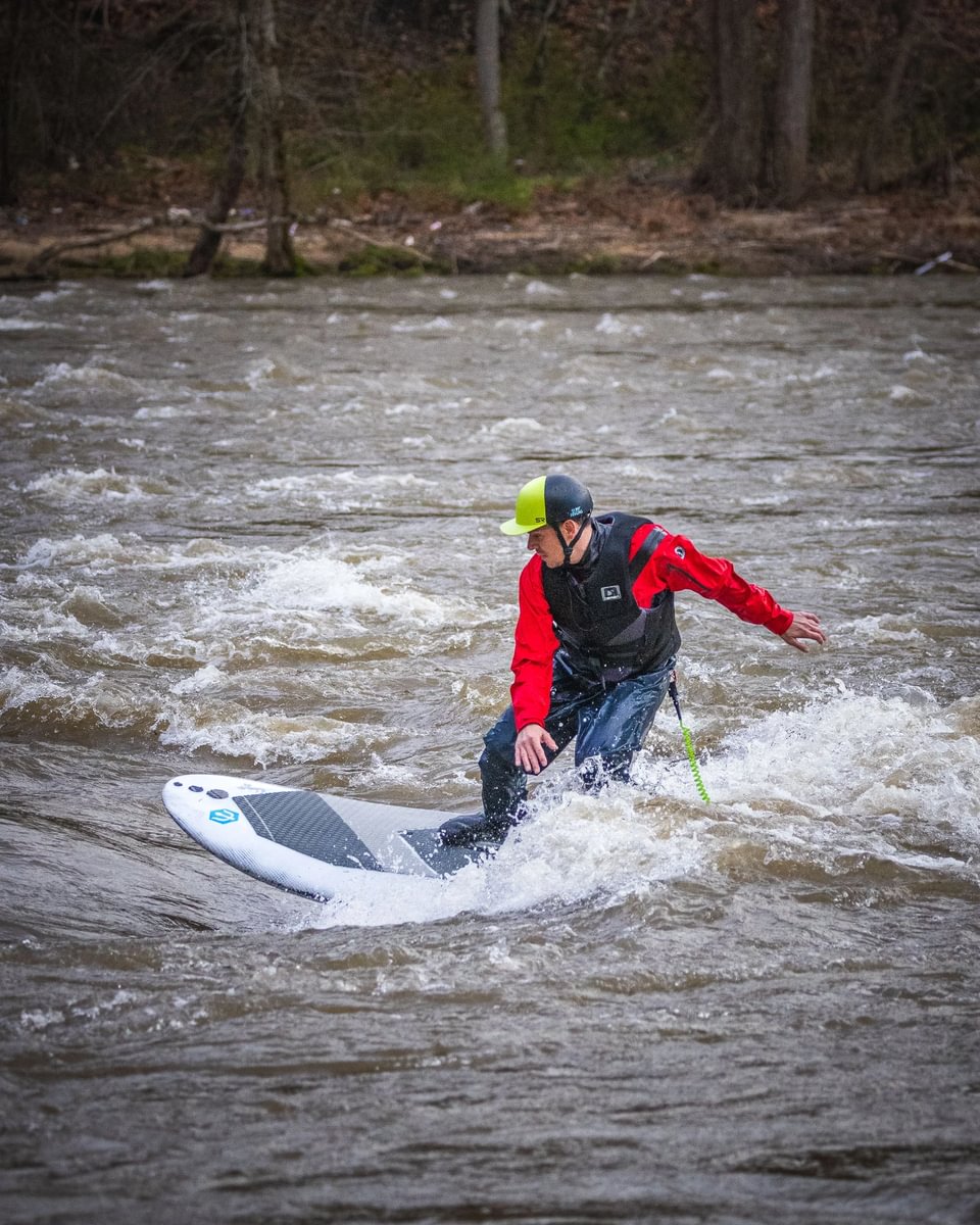 man white water river surfing