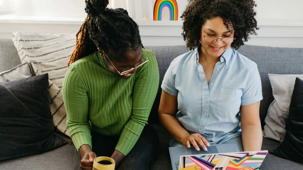 Find work, education or training Two young people laughing while on a laptop