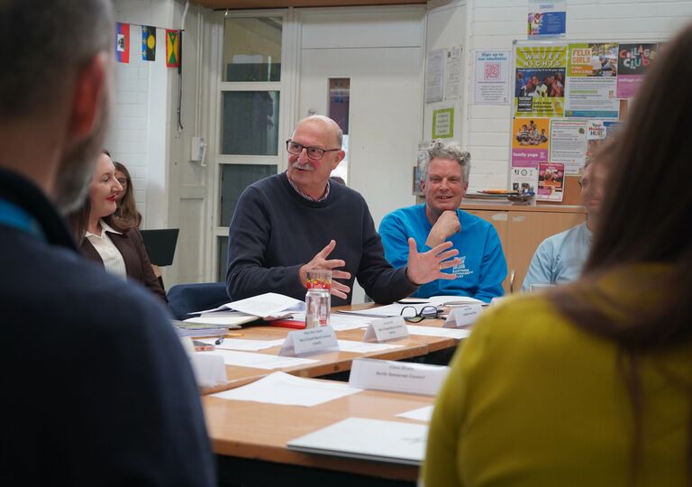 a man talks to other people around a table