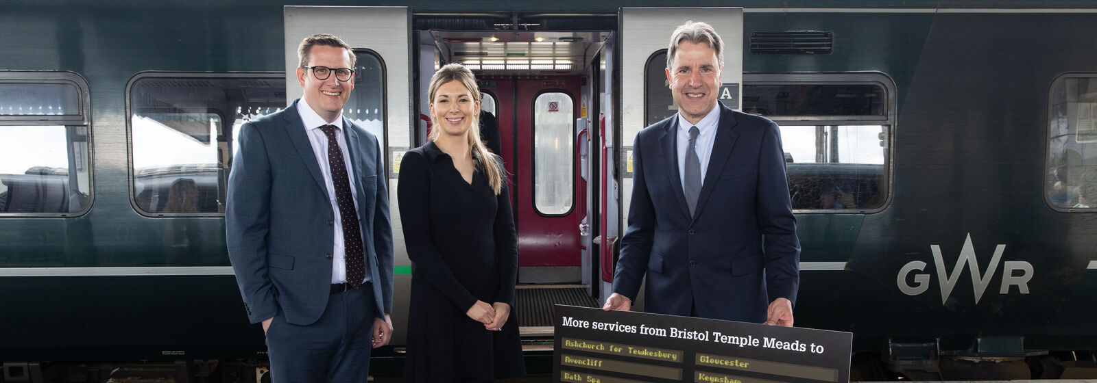 Mayor and two others stand in front of a train