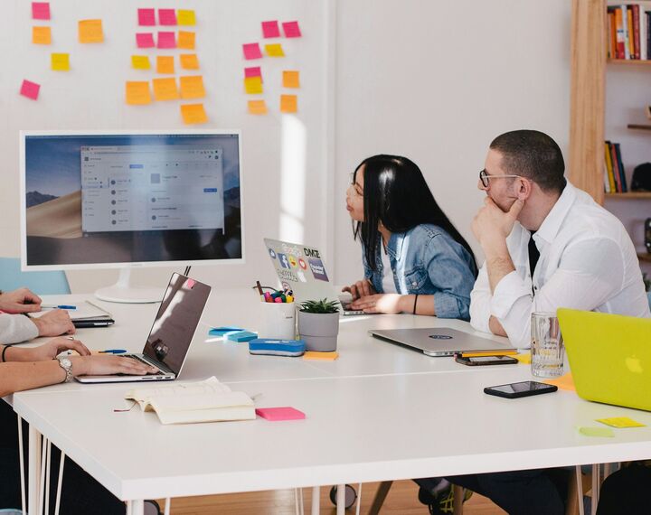 Man and woman sat at desk looking at a shared screen 