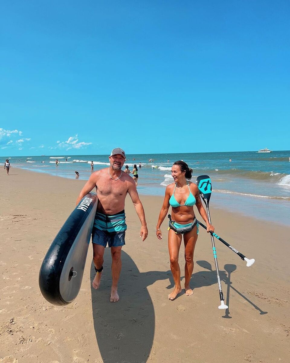 happy couple carrying paddle board