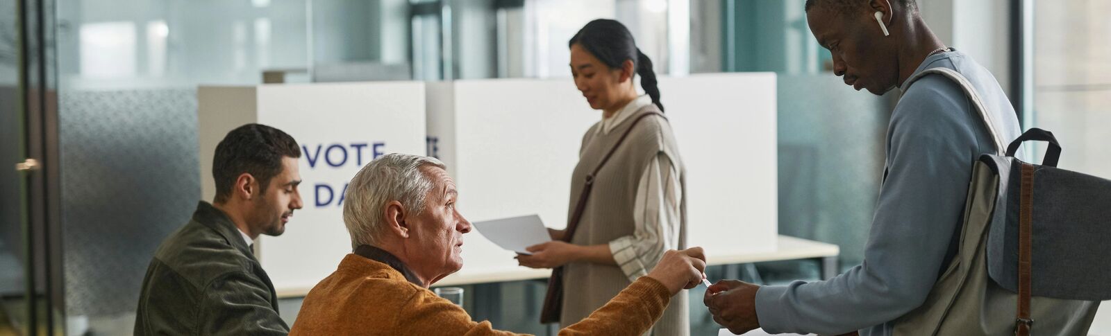 People exchanging a piece of paper in a voting station