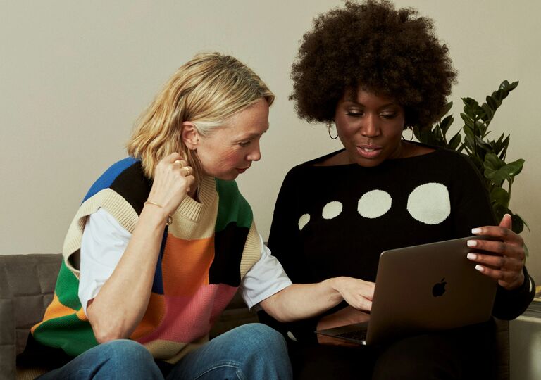 Two people using a laptop