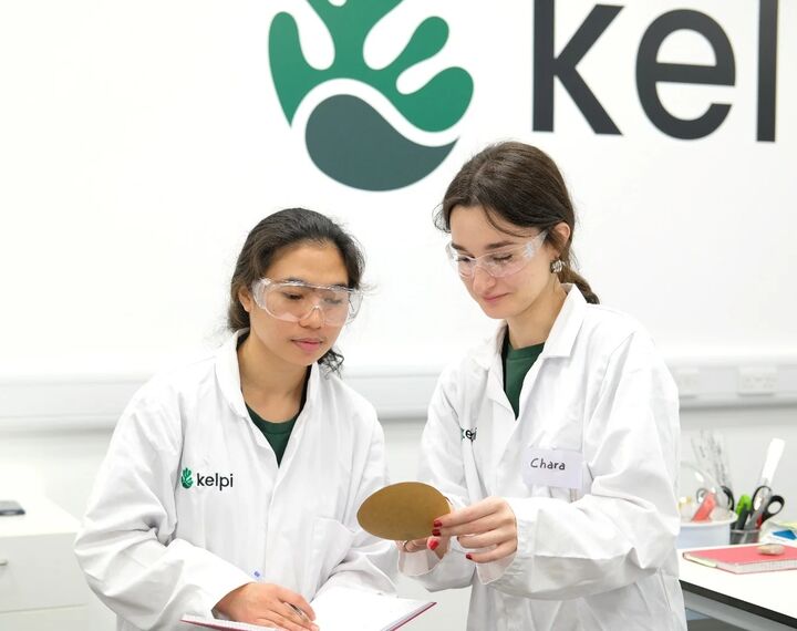 Two women looking at a paper wearing eye shield glasses 