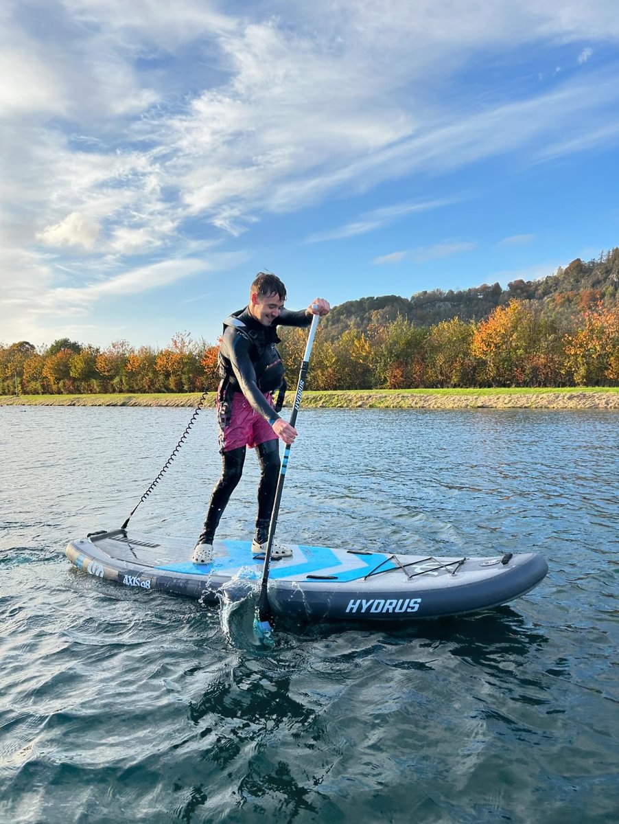 Man paddleboarding in fall