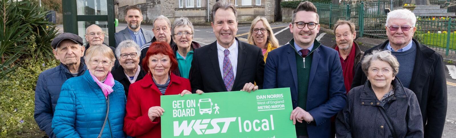 Mayor Dan Norris, Paulton Parish Councillors and local residents by the bus stop holding a sign saying WESTlocal in Paulton High Street