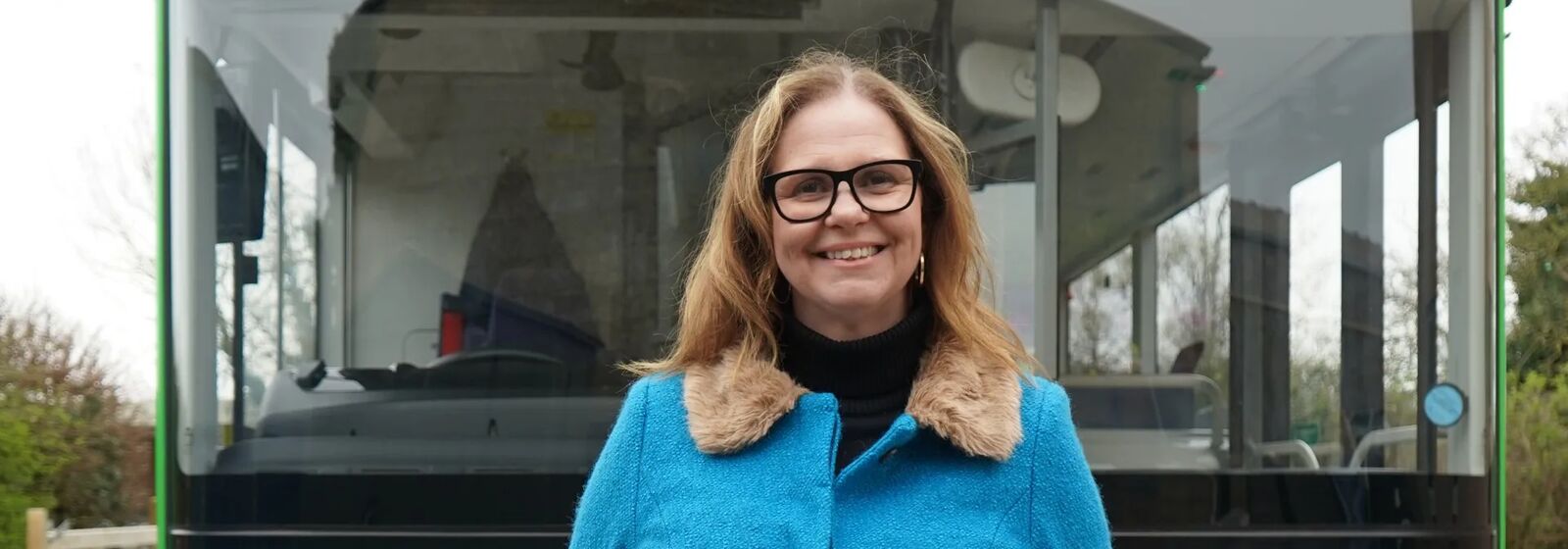 mayor helen godwin stands in front of a bus