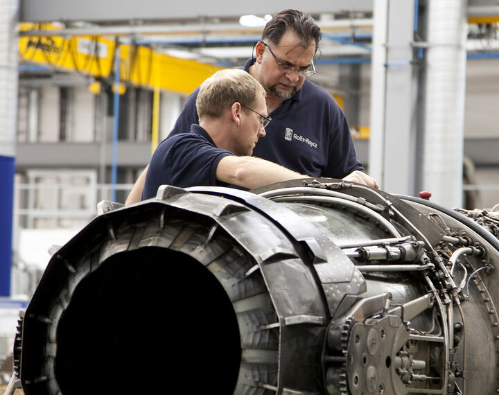 Two men working on airplane engine
