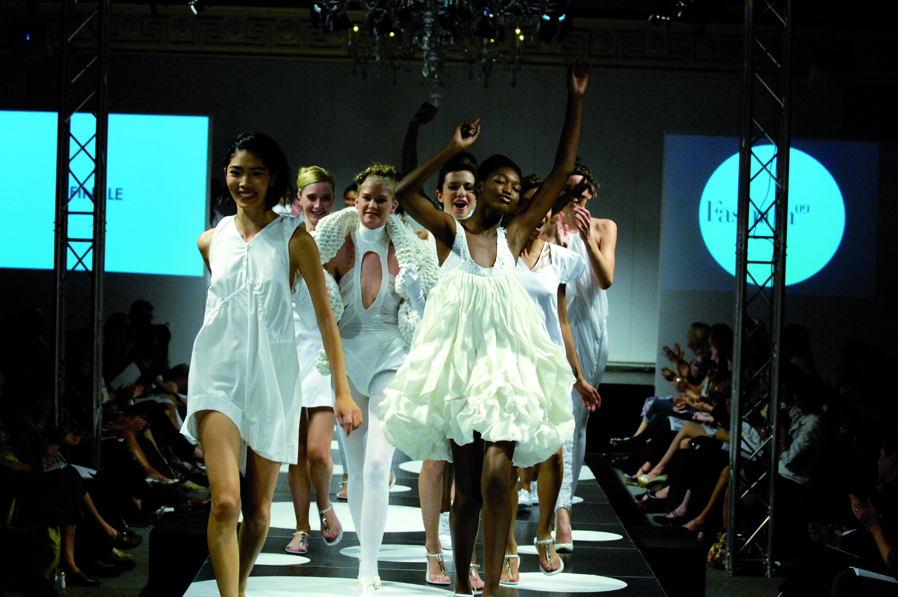 A group of young woman wearing white on a catwalk