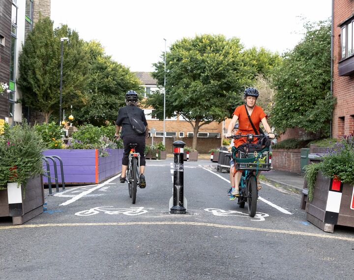 two people cycling in opposite directions