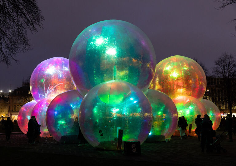 large lit up inflatable spheres at night