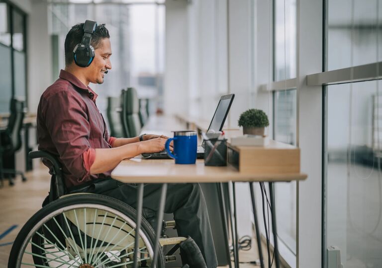 A man sitting on a wheelchair and attending a call