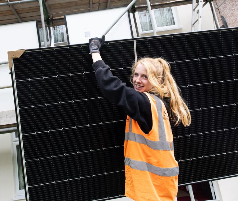 Young person carrying solar panel