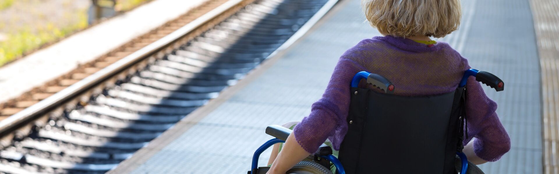 a person in a wheelchair waiting on a station platform