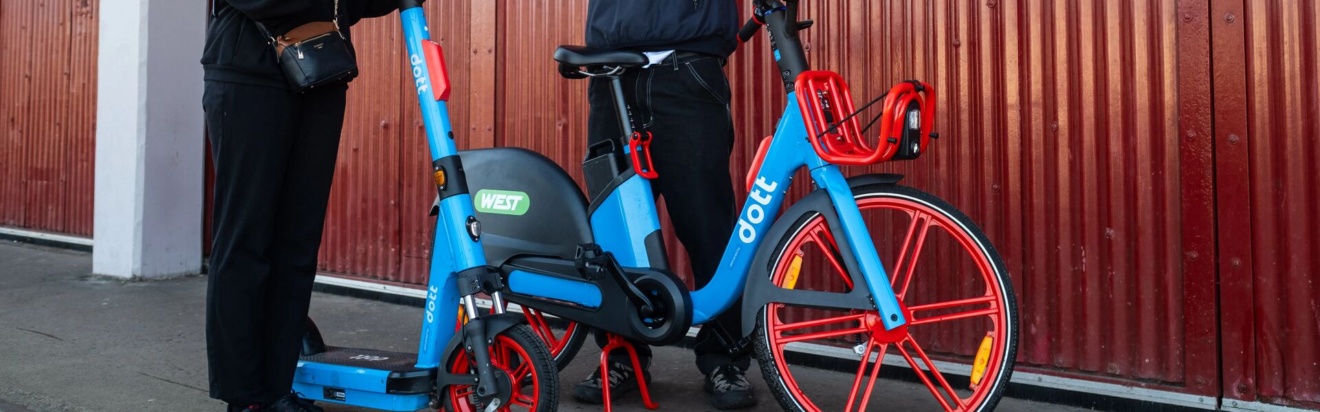 close up of e-bike with person in black clothes in front of red shutters
