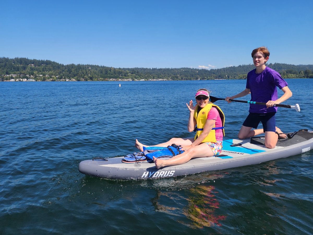 mom and son on paddleboard in lake